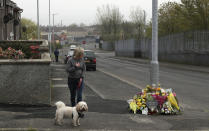 A woman reacts as she stops to pay her respects at the scene Saturday April 20, 2019, in Londonderry, Northern Ireland, where 29-year old journalist Lyra McKee was fatally shot. Police in Northern Ireland on Saturday arrested two teenagers in connection with the fatal shooting of investigative journalist Lyra McKee was shot and killed during rioting Thursday night. (Brian Lawless/PA via AP)