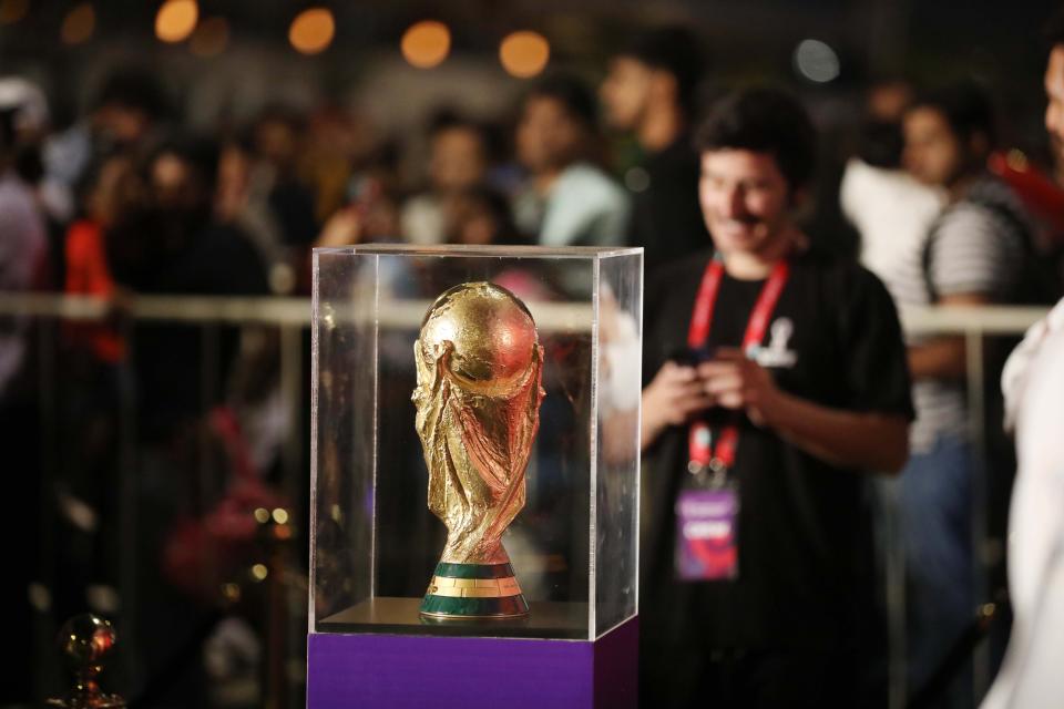 DOHA, QATAR - DECEMBER 15: People take a photo with the FIFA World Cup trophy exhibited in the Corniche Street of Doha, Qatar on December 15, 2022. (Photo by Ashraf Amra/Anadolu Agency via Getty Images)