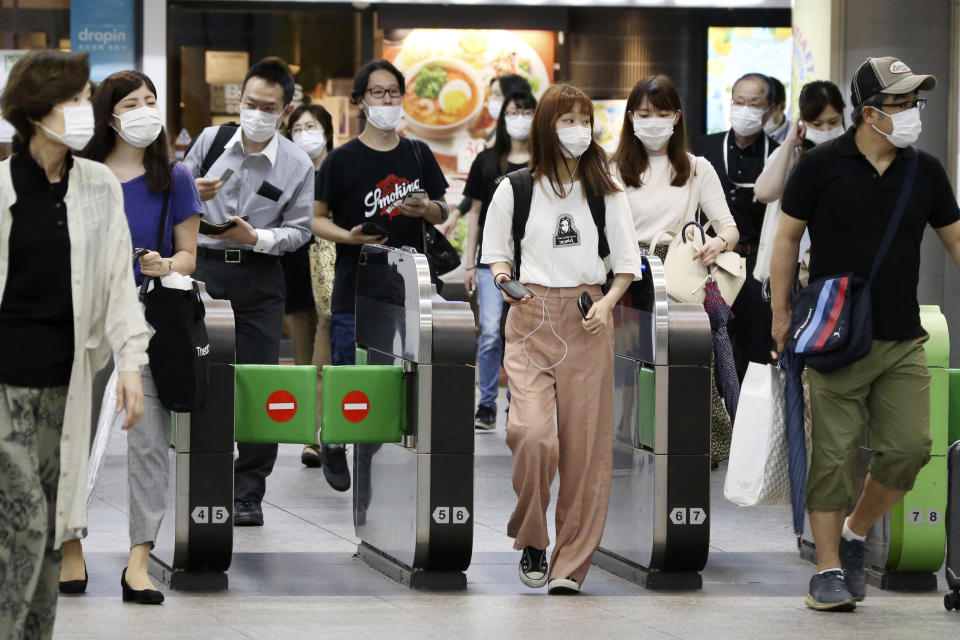 Passengers wearing face masks to protect against the spread of the new coronavirus pass the gates at Yokohama station Tuesday, July 14, 2020. (AP Photo/Koji Sasahara)