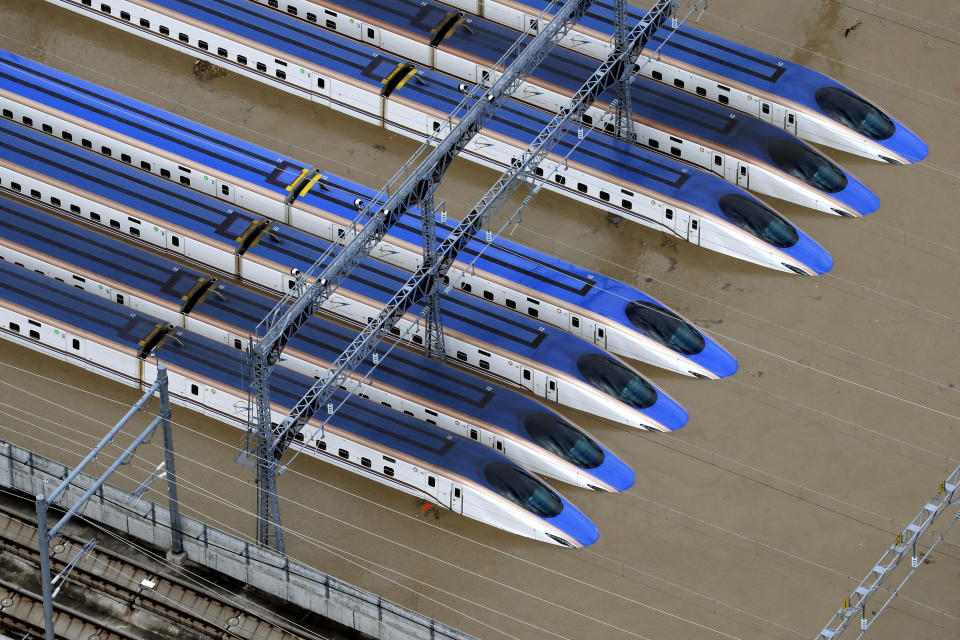 In this Sunday, Oct. 13, 2019, file photo, bullet trains are seen submerged in muddy waters in Nagano, central Japan, after Typhoon Hagibis hit the city. Rescue efforts for people stranded in flooded areas are in full force after a powerful typhoon dashed heavy rainfall and winds through a widespread area of Japan, including Tokyo. (Yohei Kanasashi/Kyodo News via AP, File)