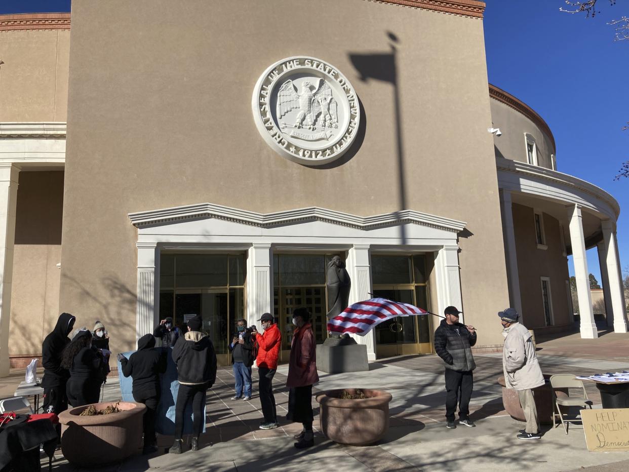 Protesters for an array of causes gather at the entrance of the New Mexico state Capitol building at the opening day of a 30-day legislative session in the House of Representatives in Santa Fe, N.M., on Tuesday, Jan. 18, 2022. New Mexico lawmakers are pushing to tap an unprecedented windfall of state income to shore up resources for public education, policing, health care and climate regulation at a 30-day legislative session. Gov. Michelle Lujan Grisham is seeking tax cuts and a crackdown on crime as she seeks reelection. (AP Photo/Morgan Lee)