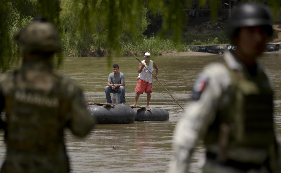 Mexican National Guards (GN) stand on the bank of the Suchiate River where porters on rafts work between Guatemala and Mexico, during a press tour organized by the GN to show their work near Ciudad Hidalgo, Mexico, Wednesday, July 3, 2019. A National Guard commander explained to the agents that they were there to support immigration enforcement, but not to interfere in the brisk and vital commerce carried out on rafts that shuttle all manner of goods between the two countries. (AP Photo/Idalia Rie)