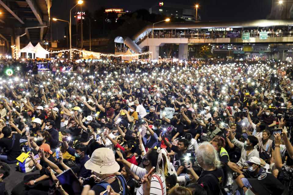 Protesters flash LED lights from their mobile phones during a rally Friday, Nov. 27, 2020 in Bangkok, Thailand. Pro-democracy demonstrators are continuing their protests calling for the government to step down and reforms to the constitution and the monarchy, despite legal charges being filed against them and the possibility of violence from their opponents or a military crackdown. (AP Photo/Wason Wanichakorn)