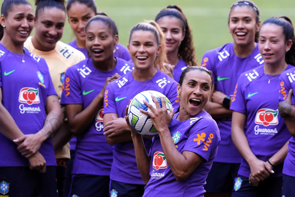 Brazilian soccer player Marta Vieira, center, holds a ball during a group photo before the start of a training session at the Mane Garrincha stadium, in Brasilia, Brazil, Saturday July 1, 2023. The Brazilian women's soccer team is scheduled to play a friendly match against Chile on Sunday, before their trip to the FIFA Women's World Cup.  (AP Photo/Eraldo Peres)