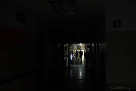 People walk in the corridors of the Central Hospital of San Cristobal during a blackout in San Cristobal, Venezuela March 14, 2018. Picture taken March 14, 2018. REUTERS/Carlos Eduardo Ramirez