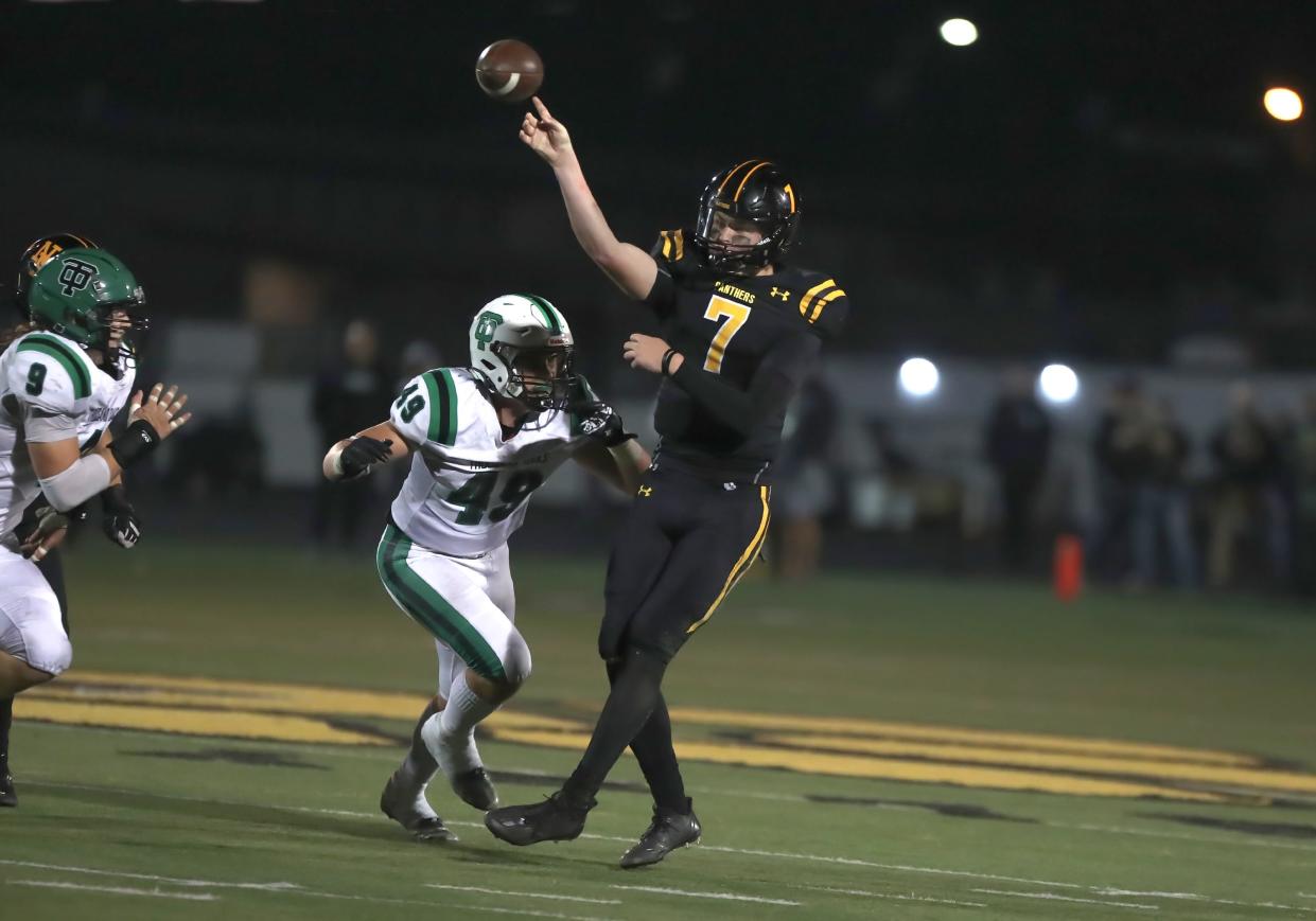 Newbury Park quarterback Brady Smigiel passes the ball while being pressured by Thousand Oaks' Bret Warner during a Canyon League game on Sept. 22. Smigiel, only a sophomore, continues to chase and break Ventura County and program records.