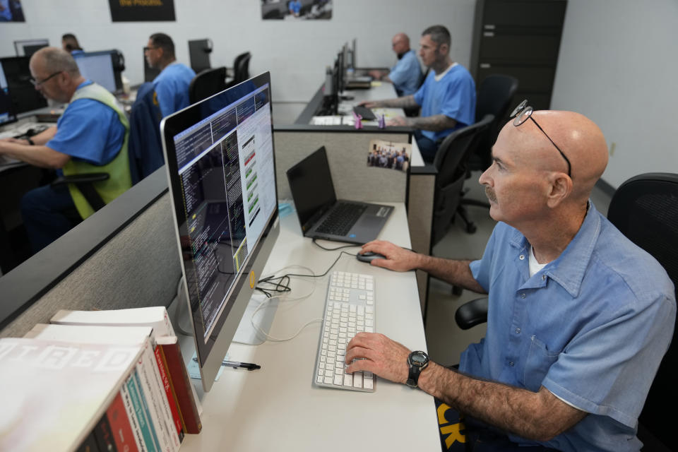 John Levin sits with other incarcerated men in the Last Mile Computer Coding program during a media tour at San Quentin State Prison in San Quentin, Calif., on July 26, 2023. California Gov. Gavin Newsom has ambitious and expensive plans for a dilapidated factory at San Quentin State Prison where inmates of one of the nation's most notorious lockups once built furniture. He wants to spend $360 million demolishing the building and replacing it with one more reminiscent of a college campus, with a student union, classrooms and possibly a coffee shop. (AP Photo/Eric Risberg)