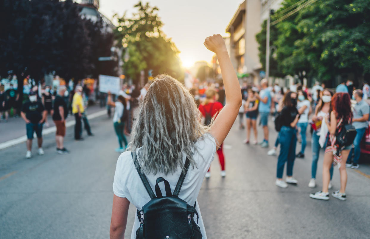 Young woman with a raised fist protesting in the street