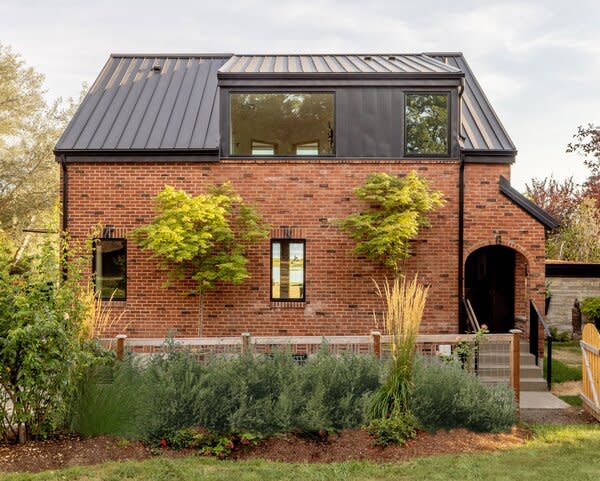 Overlooking the farmhouse orchard and garden, a new dormer at the home’s north facade incorporates windows for the primary bathroom and hall on the upper level.