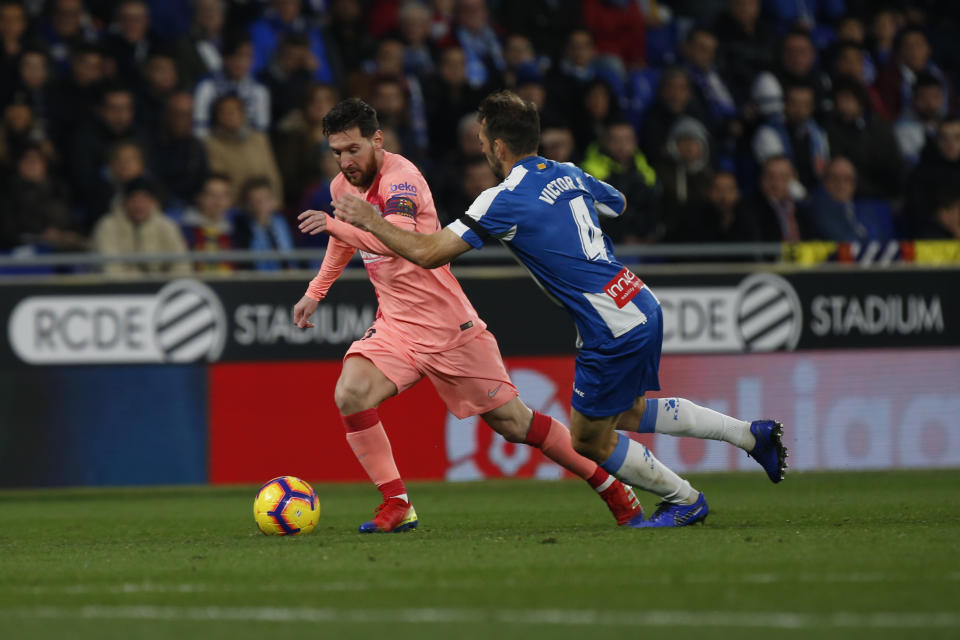 FC Barcelona's Lionel Messi, left, kicks the ball during the Spanish La Liga soccer match between Espanyol and FC Barcelona at RCDE stadium in Cornella Llobregat, Spain, Saturday, Dec. 8, 2018. (AP Photo/Joan Monfort)