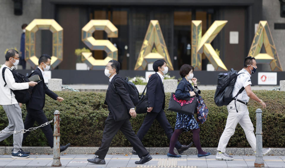 People wearing face masks to help curb the spread of the coronavirus walk in Osaka, western Japan, Friday, April 2, 2021. Semi-emergency coronavirus measures began in Osaka and its neighboring prefecture in western Japan and another prefecture in the north Monday, April 5, 2021 as Japan tries to minimize the economic impact to specific areas where infections are rising back less than four months before the Tokyo Olympics. (Yosuke Mizuno/Kyodo News via AP)