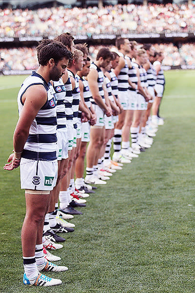 Geelong players observe a minute's silence in front of a packed crowd at Adelaide Oval.