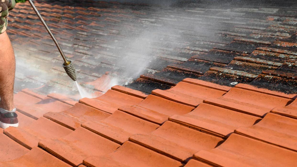 A man cleaning roof tiles