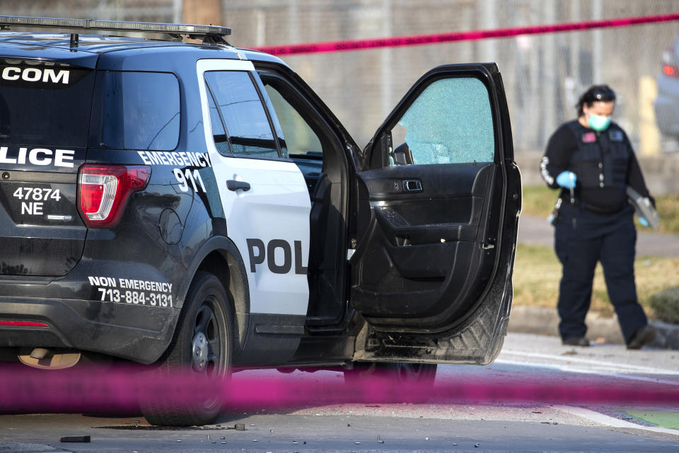 Police investigate the scene where three Houston Police Department officers were shot near the intersection of McGowen and Hutchins Thursday, Jan. 27, 2022, in Houston. Authorities say a police chase in Houston ended with a shootout that wounded the officers. The incident happened about 2:40 p.m. Thursday when a car that police were pursuing crashed at an intersection just off Interstate 69 on the southeastern edge of downtown Houston. (Brett Coomer/Houston Chronicle via AP)