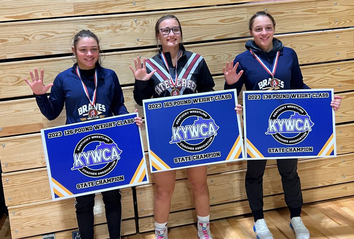 Three female wrestlers marked their fifth consecutive state titles at the Kentucky Wrestling Coaches Association’s Girls’ Wrestling State Championships on Saturday at Tates Creek High School. They are Grant County’s Olivia Messerly, left and Addison Messerly, right, and Tates Creek’s Trinity Gottler.