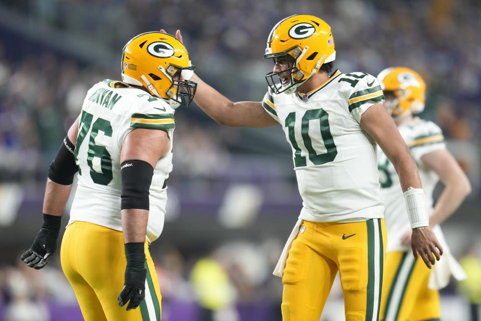 Green Bay Packers' Jordan Love celebrates his touchdown run with Jon Runyan during the first half of an NFL football game against the Minnesota Vikings Sunday, Dec. 31, 2023, in Minneapolis. (AP Photo/Abbie Parr)