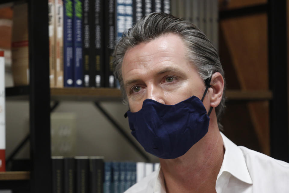 FILE - In this June 4, 2020, file photo, California Gov. Gavin Newsom wears a face mask during his stop at the Legendary Coffee and Books in Stockton, Calif. Gov. Newsom's administration on Thursday, June 18, 2020, mandated that Californians wear masks in most indoor settings as the state continues to battle the coronavirus. (AP Photo/Rich Pedroncelli, Pool, File)