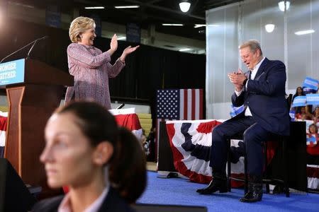 U.S. Democratic presidential nominee Hillary Clinton (L) and former Vice President Al Gore talk about climate change at a rally at Miami Dade College in Miami, Florida, U.S. October 11, 2016. REUTERS/Lucy Nicholson