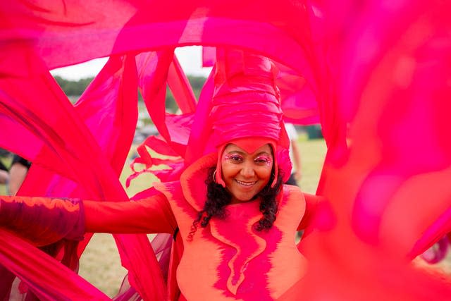 A woman wears red at the Glastonbury Festival at Worthy Farm in Somerset.