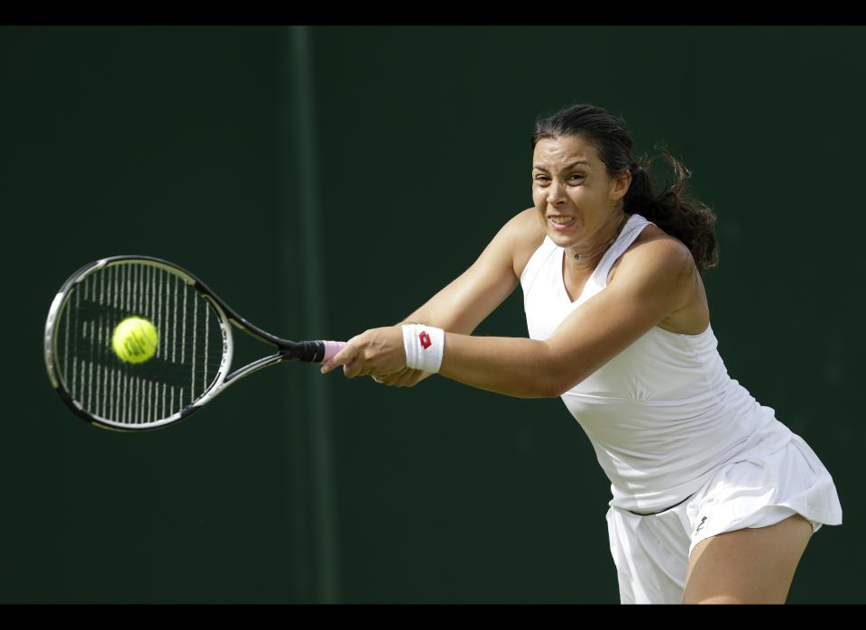 Marion Bartoli of France returns a shot to Mirjana Lucic of Croatia during a second round women's singles match at the All England Lawn Tennis Championships at Wimbledon, England, Thursday, June 28, 2012.