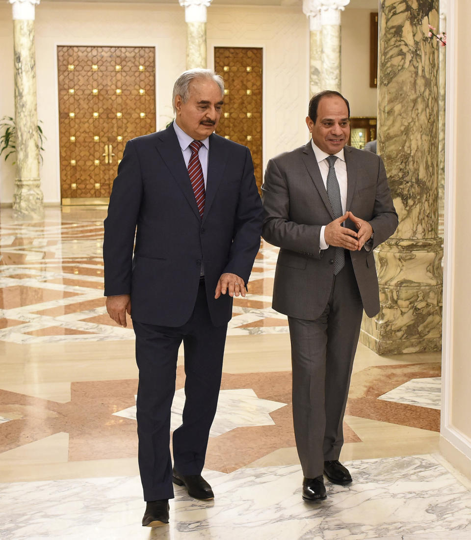 FILE - In this May 9, 2019 file photo, provided by Egypt's presidency media office, Egyptian President Abdel-Fattah el-Sissi, right, walks with Field Marshal Khalifa Hifter, the head of the self-styled Libyan National Army, in Cairo, Egypt. Libya’s eastern city of Benghazi finally feels safe again, but the city center lies in ruins, thousands of people remain displaced, and forces loyal to Hifter, who now controls eastern Libya, have cracked down on dissent. Hifter has modeled his rule on that of el-Sissi, his close ally in neighboring Egypt. Both have declared war on terrorism -- applying the term not only to extremist groups but more moderate Islamists. (Egyptian Presidency Media office via AP, File)