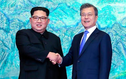 North Korean leader Kim Jong-un, left, shanks with South Korean President Moon Jae-in at the Peace House at the border village of Panmunjom  - Credit: AP