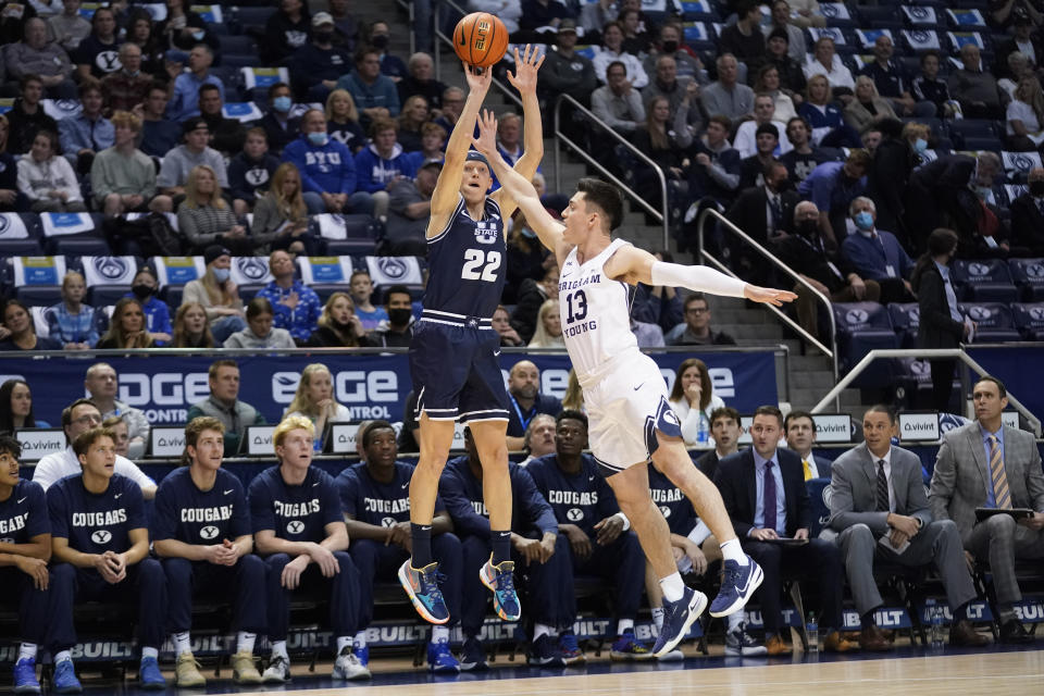 Utah State guard Brock Miller (22) shoots as BYU guard Alex Barcello (13) defends in the first half during an NCAA college basketball game Wednesday, Dec. 8, 2021, in Provo, Utah. (AP Photo/Rick Bowmer)