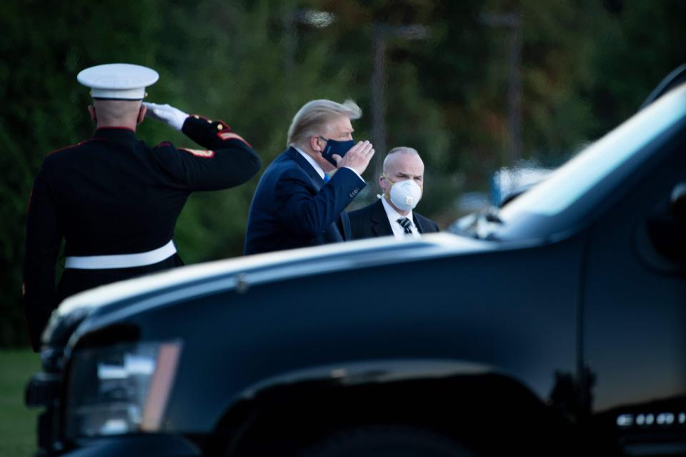 President Donald Trump walks off Marine One while arriving at Walter Reed Medical Center in Bethesda, Maryland on October 2, 2020.