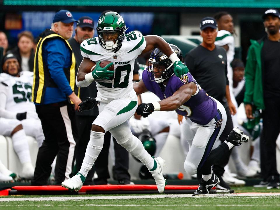 Breece Hall runs past his defender against the Baltimore Ravens.