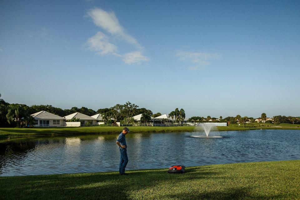 Tyler Reiter, owner of Florida Image Landscaping, Inc., shows off a Husqvarna robot grass mowing machine at Bear Island gated community in West Palm Beach, Fla., on August 10, 2023. The mowers are autonomous in the same way that popular indoor robotic floor cleaners are; self-navigating, self-charging and quiet.