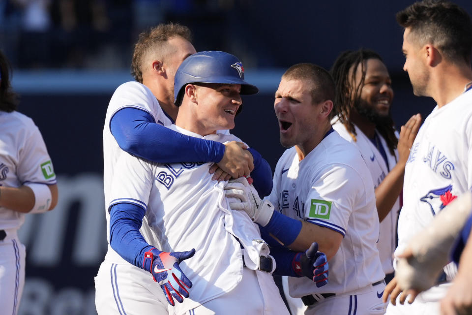 Toronto Blue' Matt Chapman, center front, celebrates with teammates George Springer, center left, and Daulton Varsho, center right, after hitting a walkoff double against the Boston Red Sox during baseball game action in Toronto, Sunday, Sept. 17, 2023. (Andrew Lahodynskyj/The Canadian Press via AP)