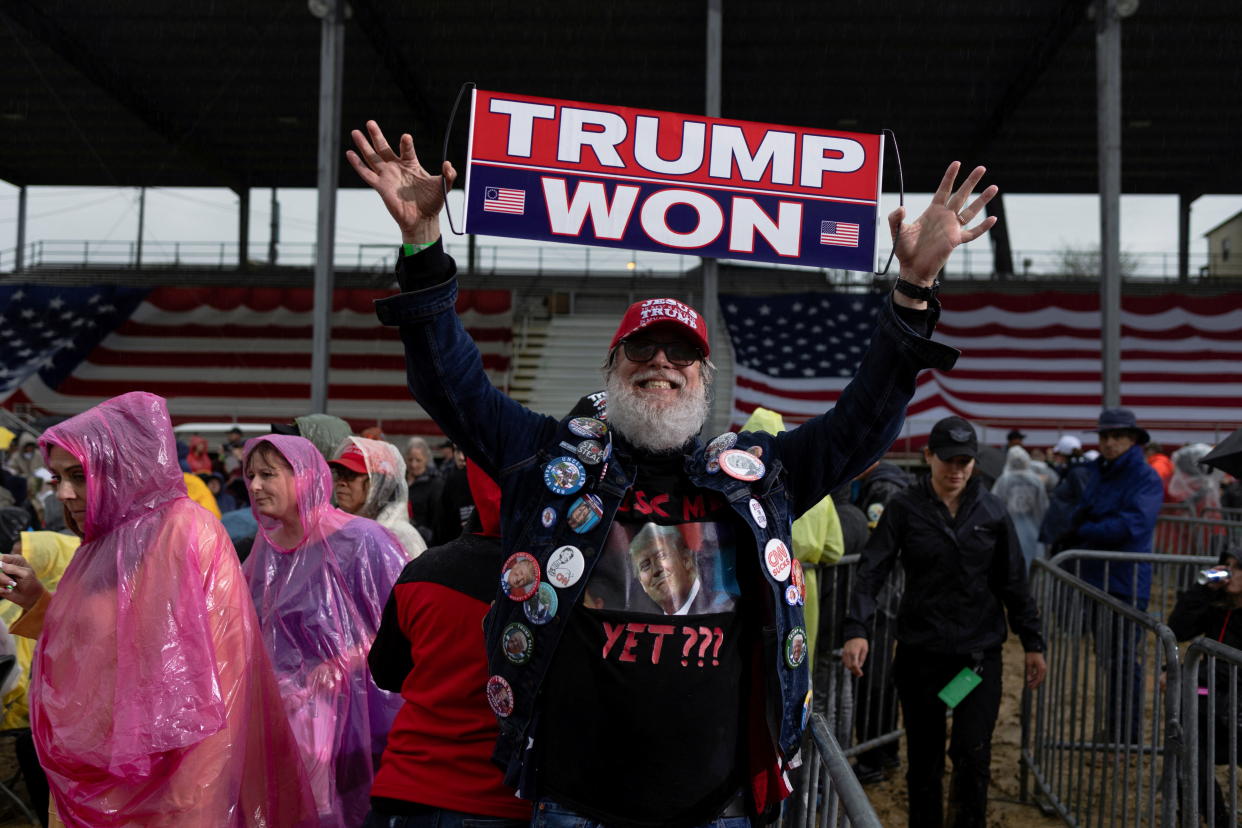A Trump supporter poses for a photo with a placard saying: Trump Won.