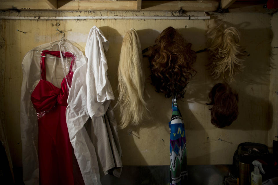 In this photo taken on Monday, July 29, 2013, Israeli Orthodox Jew Shahar Hadar's wigs and dress hang in a dressing room just before his drag queen show at a gay club in Jerusalem. Hadar, a telemarketer by day, has taken the gay Orthodox struggle from the synagogue to the stage, beginning to perform as one of Israel’s few religious drag queens. His drag persona is that of a rebbetzin, a female rabbinic advisor, a wholesome guise that stands out among the sarcastic and raunchy cast of characters on Israel’s drag queen circuit. (AP Photo/Oded Balilty)