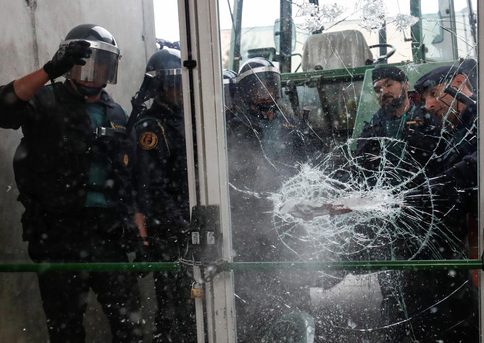 Spanish Civil Guard officers break through a door at a polling station for the banned independence referendum&nbsp;on Oct. 1, 2017. (Photo: Juan Medina / Reuters)