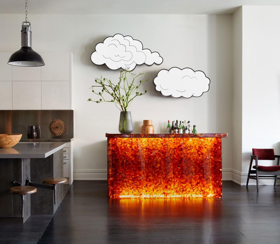 Adjacent to the kitchen is a custom backlit resin bar designed by Huniford topped with artwork by Sanford Biggers.