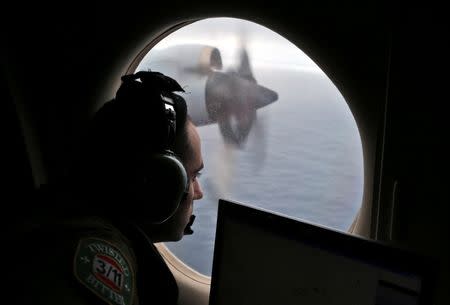 FILE PHOTO - Flight officer Rayan Gharazeddine looks out of a Royal Australian Air Force (RAAF) AP-3C Orion as it flies over the southern Indian Ocean during the search for missing Malaysian Airlines flight MH370 March 22, 2014. REUTERS/Rob Griffith/Pool/File Photo