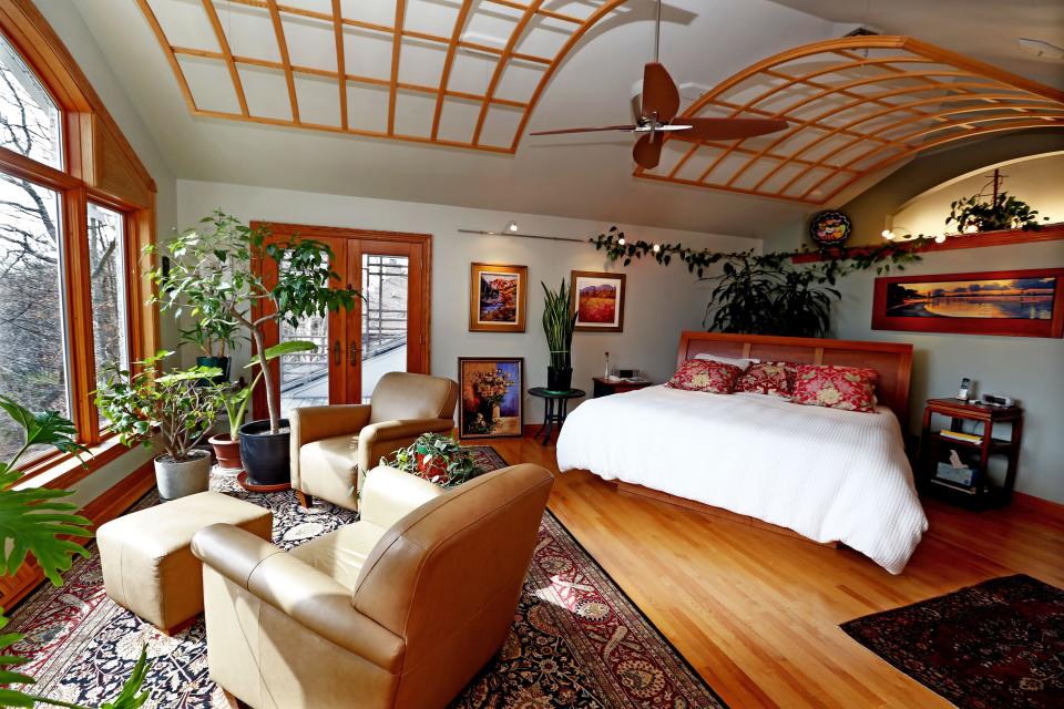 The master bedroom of Bayside homeowners Scott Kania and Linda Even has a seating area that looks down onto a ravine where salmon are known to spawn in Fish Creek. Curled wood grids hang from the ceiling. And Scott made the cherry wood bed.