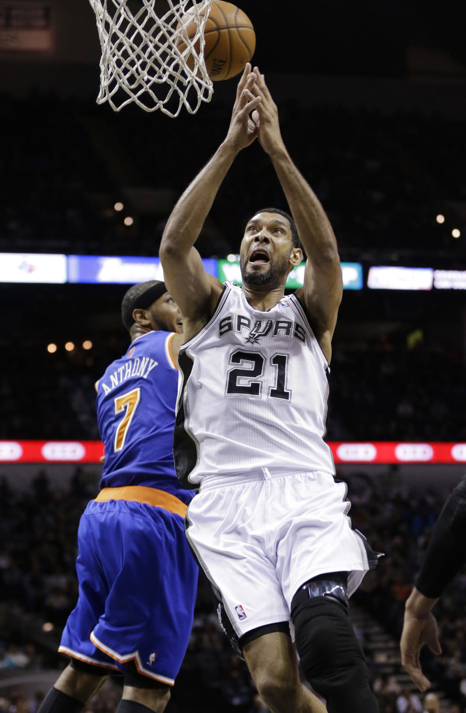 San Antonio Spurs' Tim Duncan (21) is blocked by New York Knicks' Carmelo Anthony (7) as he tries to score during the first half on an NBA basketball game, Thursday, Jan. 2, 2014, in San Antonio. (AP Photo/Eric Gay)