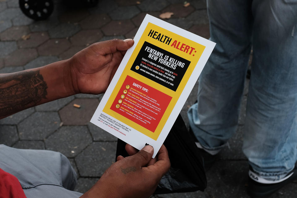 NEW YORK, NY - AUGUST 08: A heroin user reads an alert on fentanyl before being interviewed by John Jay College of Criminal Justice students as part of a project to interview Bronx drug users in order to compile data about overdoses on August 8, 2017 in New York City. The Bronx was the borough with the highest number of overdose deaths in 2016 with 308 residents. The students interview their subjects in a park and ask questions about their history of drug use and if they have overdosed.The subjects receive a small financial compensation for the research.  (Photo by Spencer Platt/Getty Images)