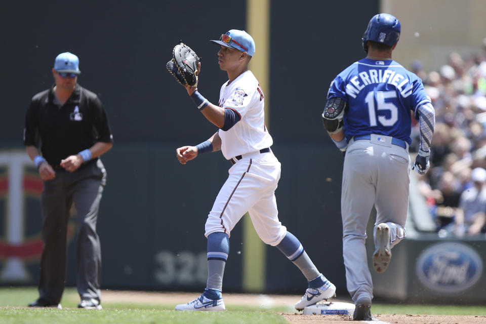 Minnesota Twins' Ehire Adrianza holds onto the ball at first to get out Kansas City Royals' Whit Merrifield during the first inning of a baseball game Sunday, June 16, 2019, in Minneapolis. Minnesota Twins' shortstop Jorge Polanco threw the ball to Adrianza for the out. (AP Photo/Stacy Bengs)