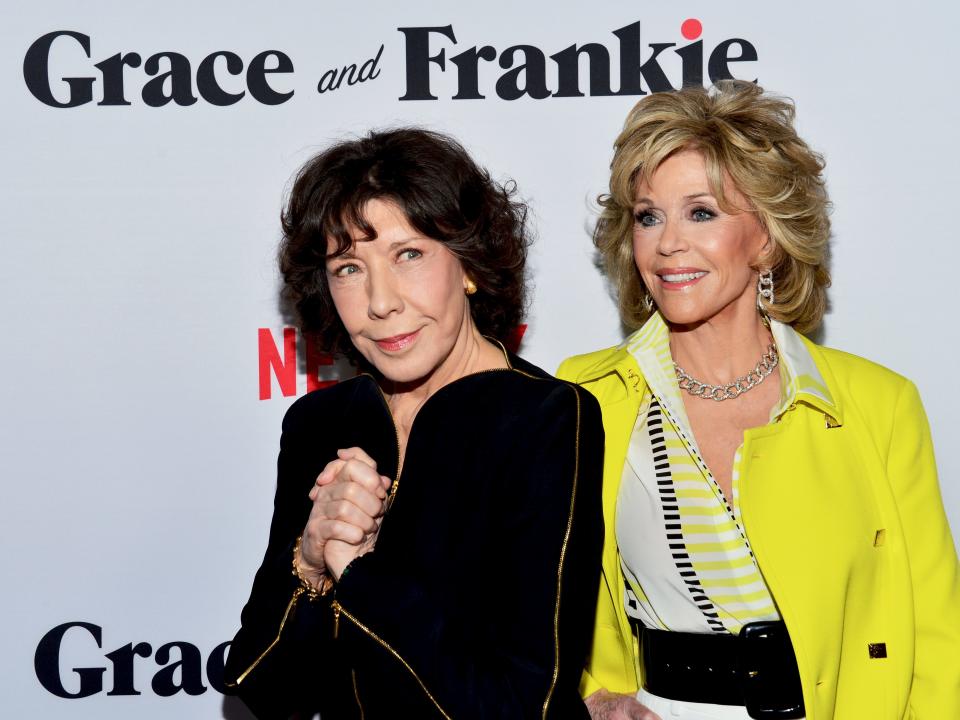 Lily and Jane smiling in front of a "Grace and Frankie" backdrop.