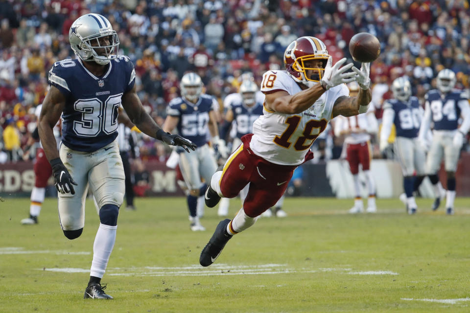 <p>Washington Redskins wide receiver Josh Doctson (18) reaches for an incomplete pass as Dallas Cowboys cornerback Anthony Brown (30) looks on during the first half of an NFL football game, Sunday, Oct. 21, 2018 in Landover, Md. (AP Photo/Andrew Harnik) </p>