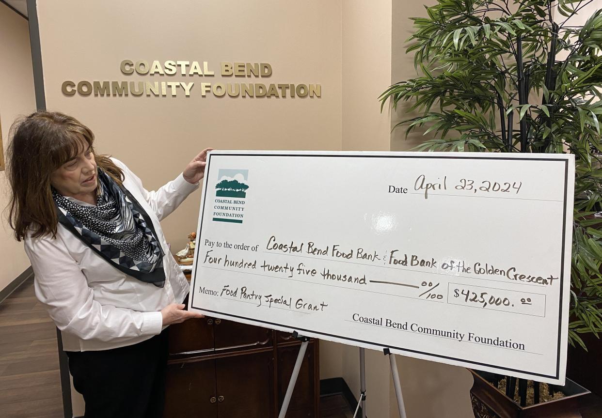 Karen Selim, president and CEO of the Coastal Bend Community Foundation, shows the $425,000 check awarded to area food banks.
