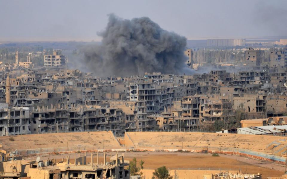 Smoke bellows from the city of Deir Ezzor, a short distance from Hajin, captured on Friday morning from Isil - AFP