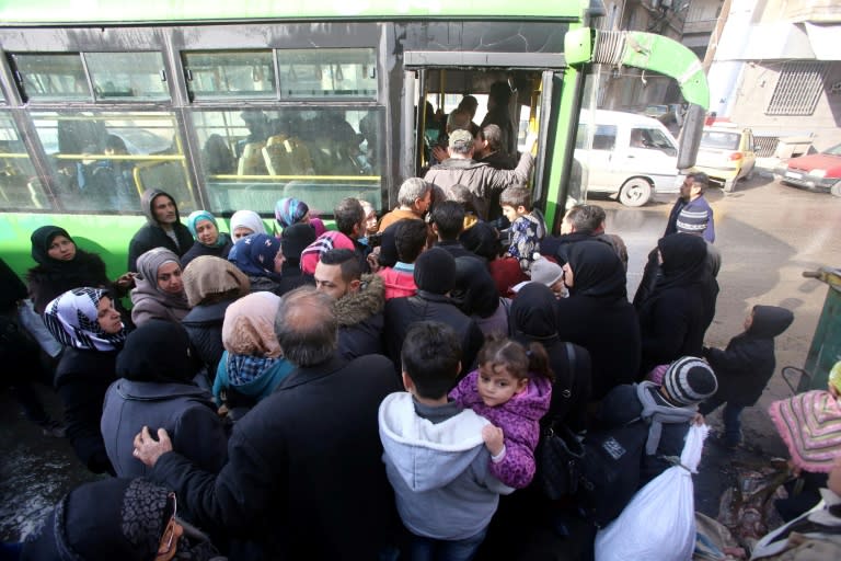 Syrians, from various western districts, board a bus at the Razi bus stop in Aleppo's central Jamiliyeh neighbourhood before the start of a bus trip through government-held territory between the two sides of the divided city on December 3, 2016