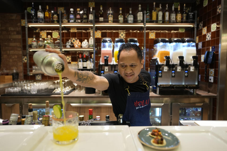 A bartender prepares a drink in a restaurant in the 22-decks cruise ship MSC World Europa, a floating hotel docked at Doha Port to offer accommodate for around 6,700 World Cup fans, in Doha, Qatar, Sunday, Nov. 13, 2022. Final preparations are being made for the soccer World Cup which starts on Nov. 20 when Qatar face Ecuador. (AP Photo/Hassan Ammar)