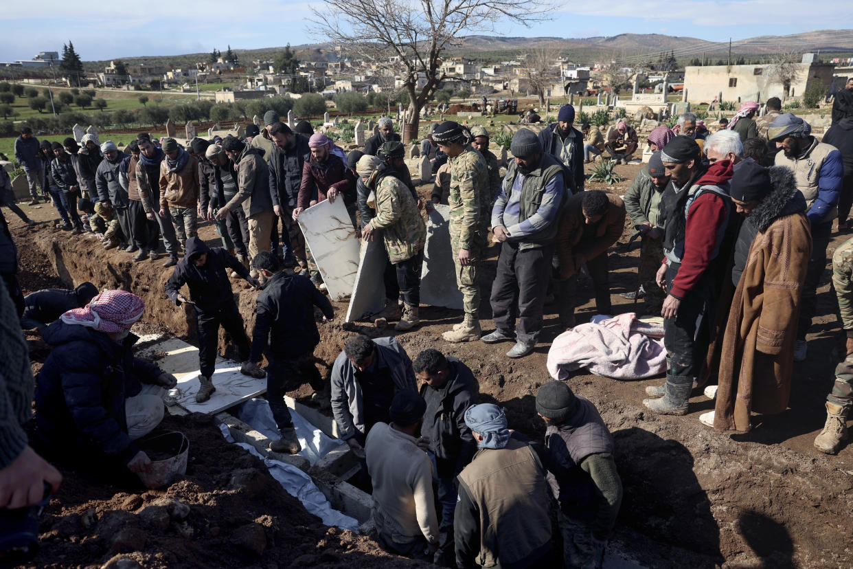 Mourners bury family members who died in a devastating earthquake that rocked Syria and Turkey at a cemetery in the town of Jinderis, Aleppo province, Syria, Tuesday, Feb. 7, 2023. A newborn girl was found buried under debris with her umbilical cord still connected to her mother, Afraa Abu Hadiya, who was found dead, according to relatives and a doctor. The baby was the only member of her family to survive from the building collapse Monday in Jinderis, next to the Turkish border, Ramadan Sleiman, a relative, told The Associated Press. (AP Photo/Ghaith Alsayed)