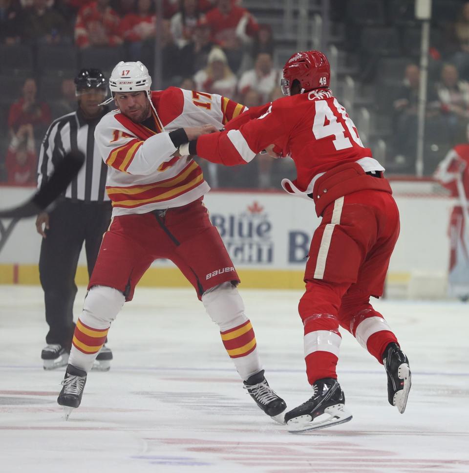 Detroit Red Wings left wing Givani Smith (48) and Calgary Flames left wing Milan Lucic (17) fight during first-period action Thursday, Oct. 21, 2021 at Little Caesars Arena.