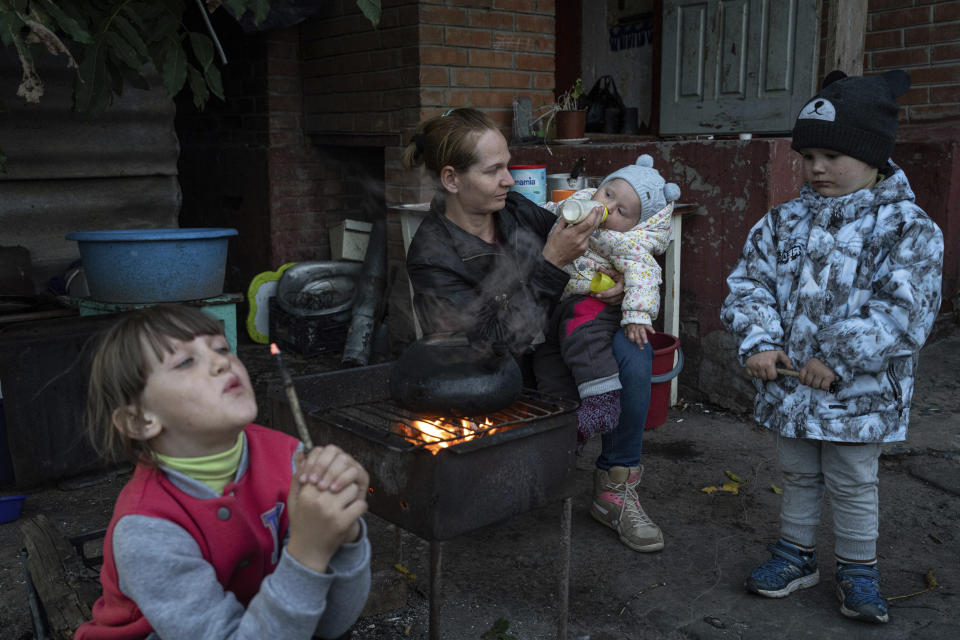 FILE - Margaryta Tkachenko feeds her 9-month-old daughter Sophia in the recently liberated town of Izium, Ukraine, on Sept. 25, 2022. Hundreds of children from eastern Ukraine are stranded in Russian summer camps, on the wrong side of a frontline that shifted after they were bused away for what was supposed to be holiday. Tkachenko, was among those who refused an offer she said sounded too good to be true. She rejected the Russian soldiers who came to her roofless home to press the issue. (AP Photo/Evgeniy Maloletka, File)