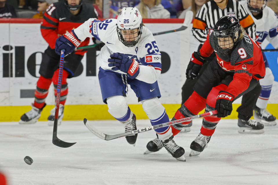 United States forward Alex Carpenter (25) races to the puck ahead of Canada forward Jessie Eldridge (9) in the second period of a women's Rivalry Series hockey game Sunday, Feb. 11, 2024, in St. Paul, Minn. (AP Photo/Bruce Kluckhohn)